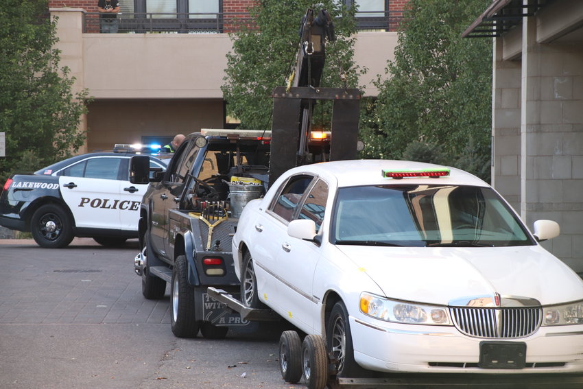 A tow truck sits with a stolen car fastened to it on Oct. 14 in Englewood after a driver in that car led police on a chase through Lakewood, Denver and Englewood.